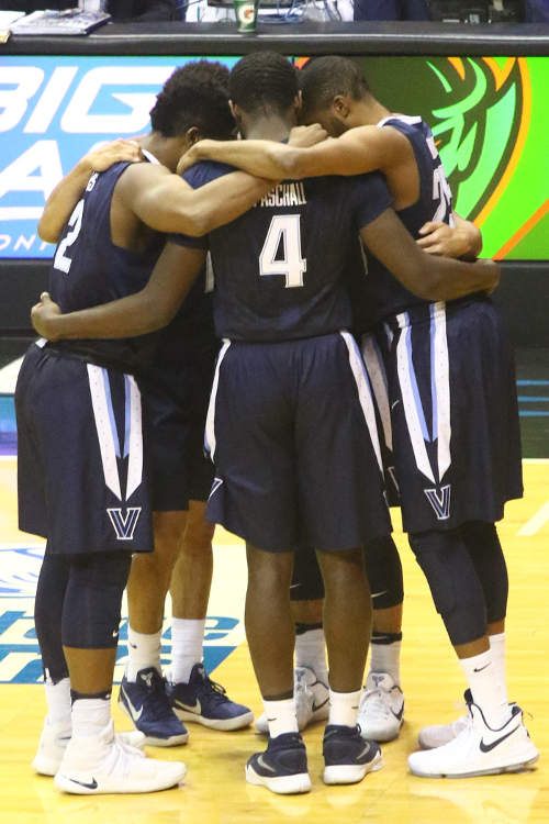 An image was here of 5 basketball players facing each other in a tight huddle.